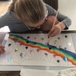 Mare kan zich creatief zo goed uiten. Hier schildert zij een regenboog van ecoline. Als ze klaar is luisteren we naar haar verhaal.